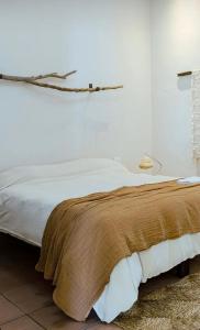 Una cama con una manta marrón encima. en Casa Fran en General Villegas