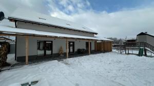 Svätý Kríž的住宿－Apartment house with sauna and jacuzzi Svätý Kríž 2，前面的地面上积雪的房子