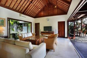 uma sala de estar com sofás e uma mesa de madeira em Jimbaran Luxury 4BR with Butler em Jimbaran