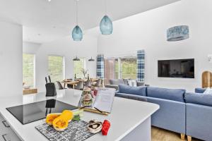 a living room with a white table and a blue couch at No 8 The Vista, Willingcott, Woolacombe in Woolacombe