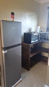 a kitchen with a refrigerator and a wooden desk at Airport Airbnb family units in Richards Bay