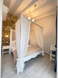 a bedroom with a canopy bed with curtains at Selin Hotel in Alacati