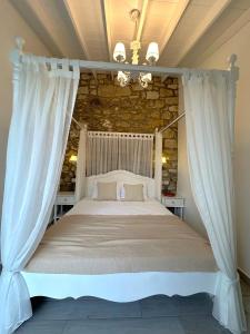 1 dormitorio con 1 cama blanca con dosel en Selin Hotel, en Alacati
