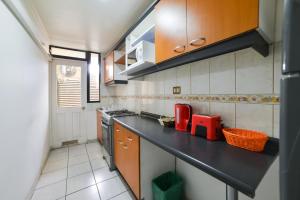 a kitchen with a black counter top in a room at Home Apartments in Los Ángeles