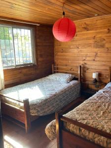 1 dormitorio con 2 camas en una cabaña de madera en Casa en algarrobo con hermosa vista al mar, en Algarrobo