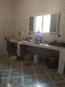 a kitchen with a sink and a counter with a window at Dar Daoudi in Nouakchott
