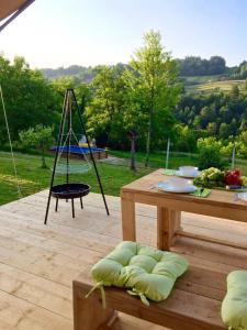 a wooden deck with a table and a swing at Camping Sretanwolf in Bosiljevo