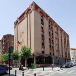 un edificio en una calle de la ciudad con un scooter delante en Pacoche Murcia en Murcia