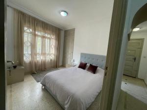 a bedroom with a bed and a large window at Ideal location in the heart of L’hivernage in Marrakesh
