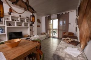 uma sala de estar com uma mesa de madeira e um sofá em 208 - Appartamento Quercia, Giardino e Piscina - Residence Cherry House em Carro
