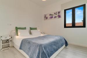 フンシャルにあるLazareto Apartment by HR Madeiraの白いベッドルーム(ベッド1台、窓付)