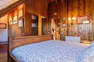 um quarto com uma cama numa parede de madeira em Baqueira Apartamentos Cota 1700 a pie de pistas em Baqueira-Beret