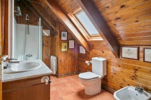 baño de madera con aseo y lavamanos en Baqueira Apartamentos Cota 1700 a pie de pistas, en Baqueira Beret