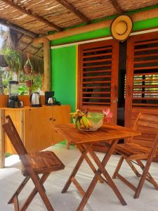 a table with a bowl of bananas and two chairs at Côco Verde Chalé - Icaraí Kite Village in Icaraí