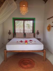 a large bed in a bedroom with flowers on it at Côco Verde Chalé - Icaraí Kite Village in Icaraí