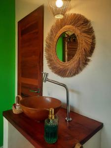 La salle de bains est pourvue d'un lavabo en bois et d'un miroir. dans l'établissement Côco Verde Chalé - Icaraí Kite Village, à Icaraí