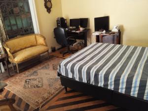 a bedroom with a bed and a chair and a desk at Estúdios Deluxe São Manuel in Rio de Janeiro