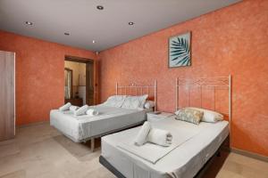 two beds in a room with orange walls at Villa Soler House in Malaga by Costarentals - MAL03 in Málaga