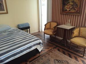 a bedroom with a bed and two chairs and a table at Estúdios Deluxe São Manuel in Rio de Janeiro