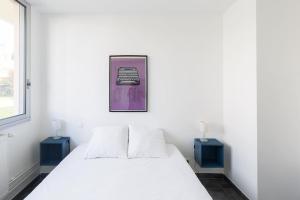 a bedroom with a white bed and two blue tables at Ephemoria - Appartement familial proche Cathédrale in Reims