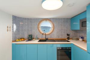 a kitchen with blue cabinets and a round window at Laguna Blu in Vietri sul Mare