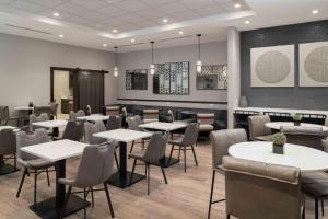 uma sala de jantar com mesas e cadeiras brancas em TownePlace Suites by Marriott Framingham em Framingham