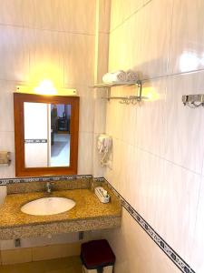 La salle de bains est pourvue d'un lavabo et d'un miroir. dans l'établissement Hong Ha Airport Hotel, à Thach Loi