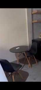 ein schwarzer Tisch und zwei Stühle in einem Zimmer in der Unterkunft Chalé praia Parracho ( Arraial ) in Porto Seguro