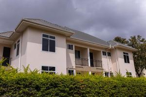 a large white building with a black roof at OLMOTI SUITES in Arusha