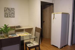 um quarto com um frigorífico, uma mesa, uma mesa e uma cadeira em AP 41- Apart OH em Ciudad del Este