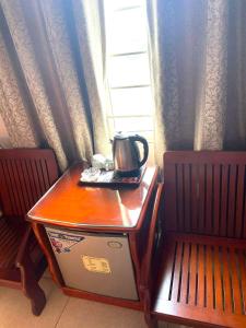 un hervidor de agua en una mesa junto a una ventana en Hong Ha Airport Hotel, en Thach Loi