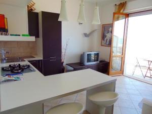 a kitchen with a white counter top and a tv at Trilocale fronte mare a Marcelli - M210 in Marcelli