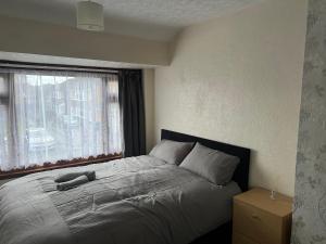 a bedroom with a large bed with a window at Five Oaks House- Entire 3 Bedroom House for Family & Contractors with up to 5 sleep- NO PARTIES ALLOWED in Willenhall