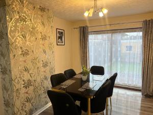 a dining room with a table and chairs and a window at Five Oaks House- Entire 3 Bedroom House for Family & Contractors with up to 5 sleep- NO PARTIES ALLOWED in Willenhall