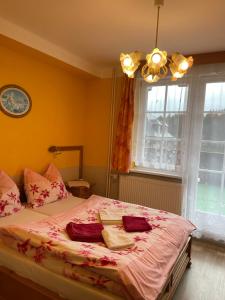 a bedroom with a bed with pink sheets and a window at Pension Švýcarský dům in Trutnov