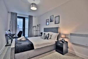 una camera con un grande letto e una grande finestra di KA Propertiess - 2Bed & 2Baths Ensuite, Parking, Balcony, Wi-Fi, Netflix, Media City a Manchester