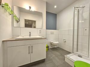 a white bathroom with a sink and a toilet at Mienhus Apartments Ferienwohnung Fiete in Norden +39 photos