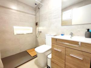 a bathroom with a toilet and a sink at Pool Apartment Maspalomas by Wave Properties in San Bartolomé de Tirajana