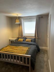 a bedroom with a large bed with a window at Spacious Apartment near Heathrow with Allocated Parking in Uxbridge