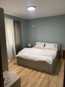 a bedroom with a large bed with a wooden floor at Itan’s apartments in Tirana