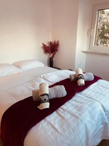 um quarto com uma cama grande com duas bonecas em Apartments Nina em Koper