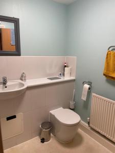 a bathroom with a white toilet and a sink at Spacious Apartment near Heathrow with Allocated Parking in Uxbridge