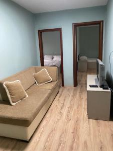 a living room with a couch and a desk with a computer at Itan’s apartments in Tirana