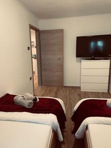 a room with two beds and a flat screen tv at Apartments Nina in Koper