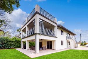 a white house with a balcony on top of it at Gather Together - Unit 145 in Marco Island