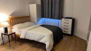 1 dormitorio con 1 cama, vestidor y ventana en Large 3 Bed Apt close to city, OVO Hydro and Ibrox Stadium en Glasgow