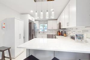 cocina con armarios blancos y encimera blanca en Gather Together - Unit 145, en Marco Island