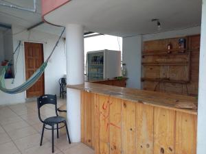 a kitchen with a wooden counter and a chair at Hostal Continental in Manta