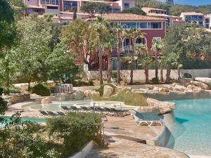 um resort com uma piscina com cadeiras e um resort em Les Restanques 4027 vue mer grande terrasse em Grimaud
