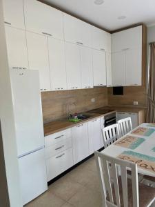 都拉斯的住宿－Blue Panorama 2!，厨房配有白色橱柜和桌椅